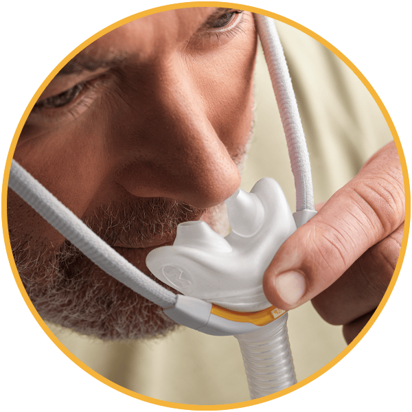Fisher and Paykel Nasal Pillows mask being pulled away from a mans face.