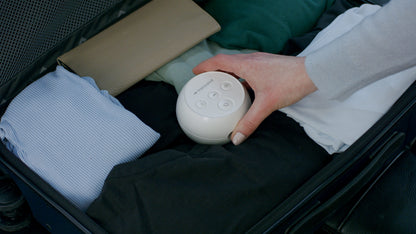 Transcend Micro APAP Machine being placed into a suitcase filled with clothing, showcasing its compact size.